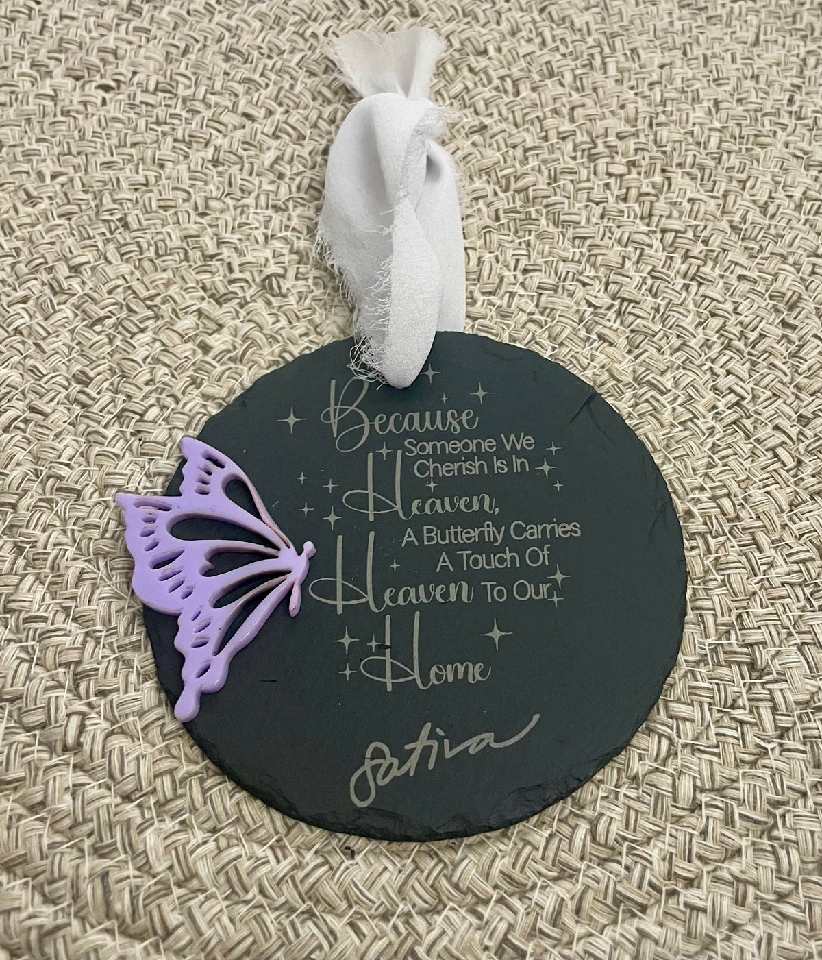 Round black slate ornament with butterfly decoration and text